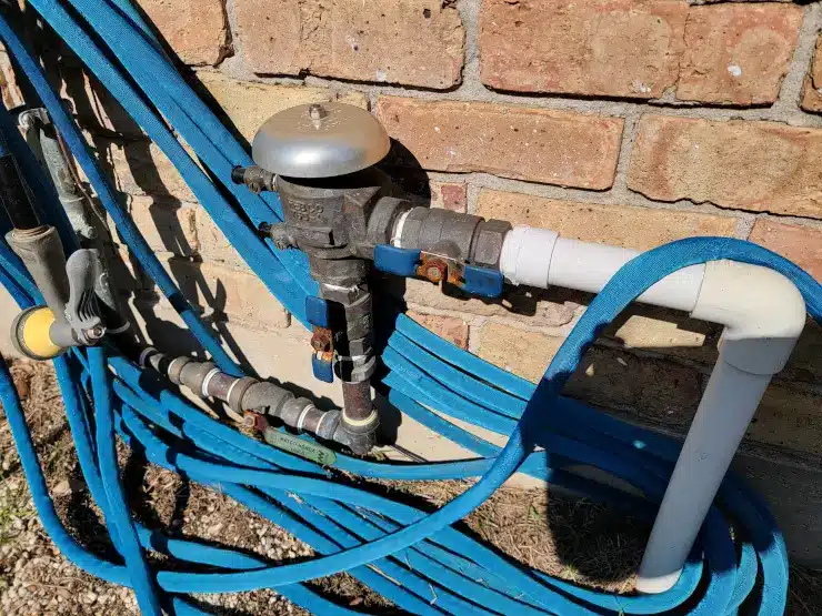 A pressure vacuum breaker, the most common residential backflow prevention device, on an outdoor irrigation line