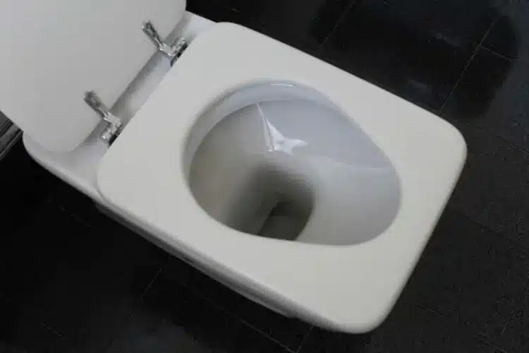 Looking down into an open toilet bowl before using dish soap and hot water to unclog a toilet